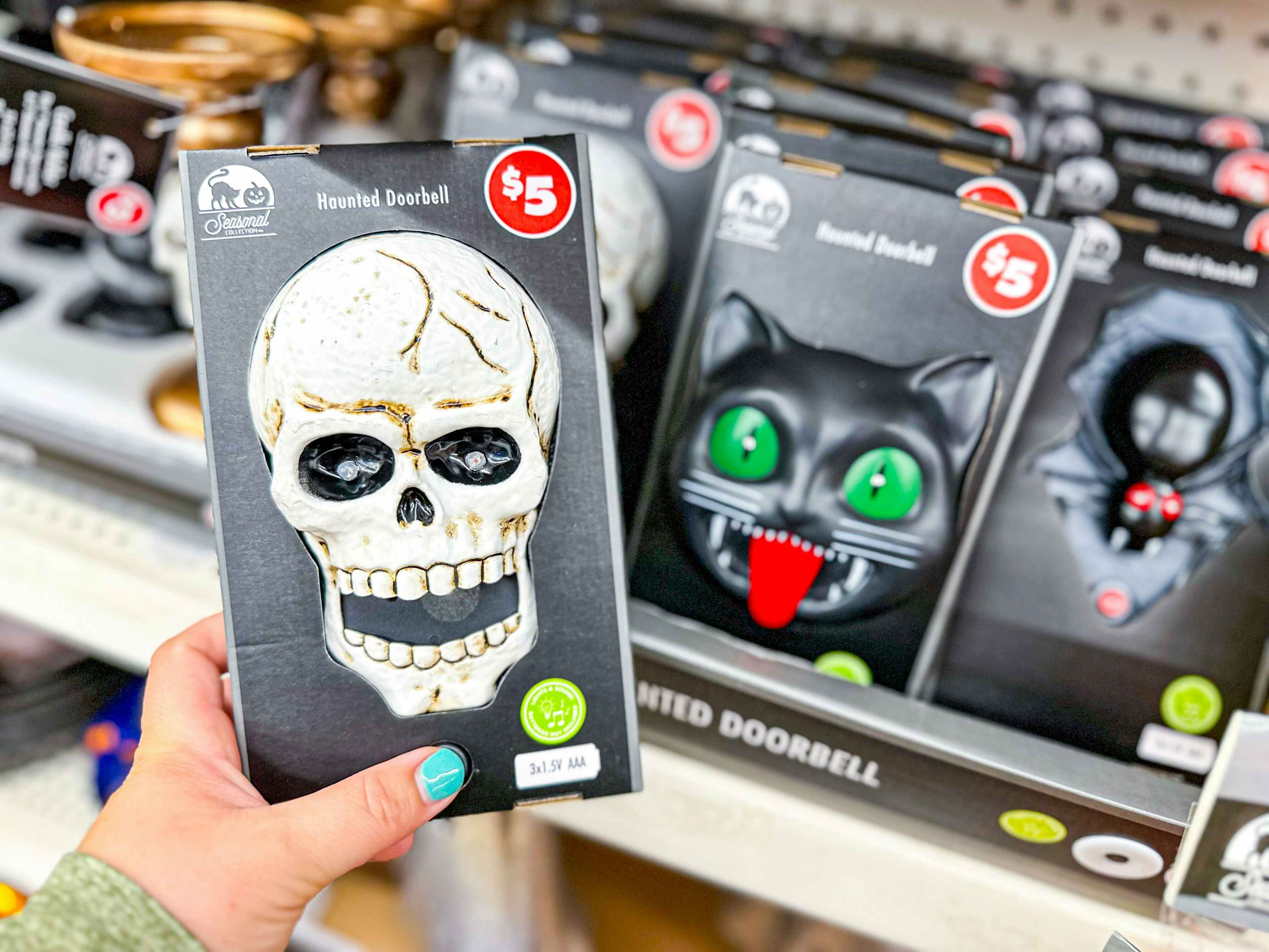 person holding a skull doorbell