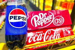 pepsi, dr peppers, and coca-cola products in a yellow shopping cart