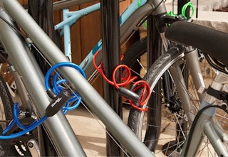 blue, green, and red Master Lock bike lock cables wrapped around bikes and bike stations