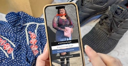 Someone holding a phone displaying the Depop app in front of some clothing and shoes