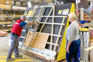 a customer waiting for her wood to be cut by a lowes employee