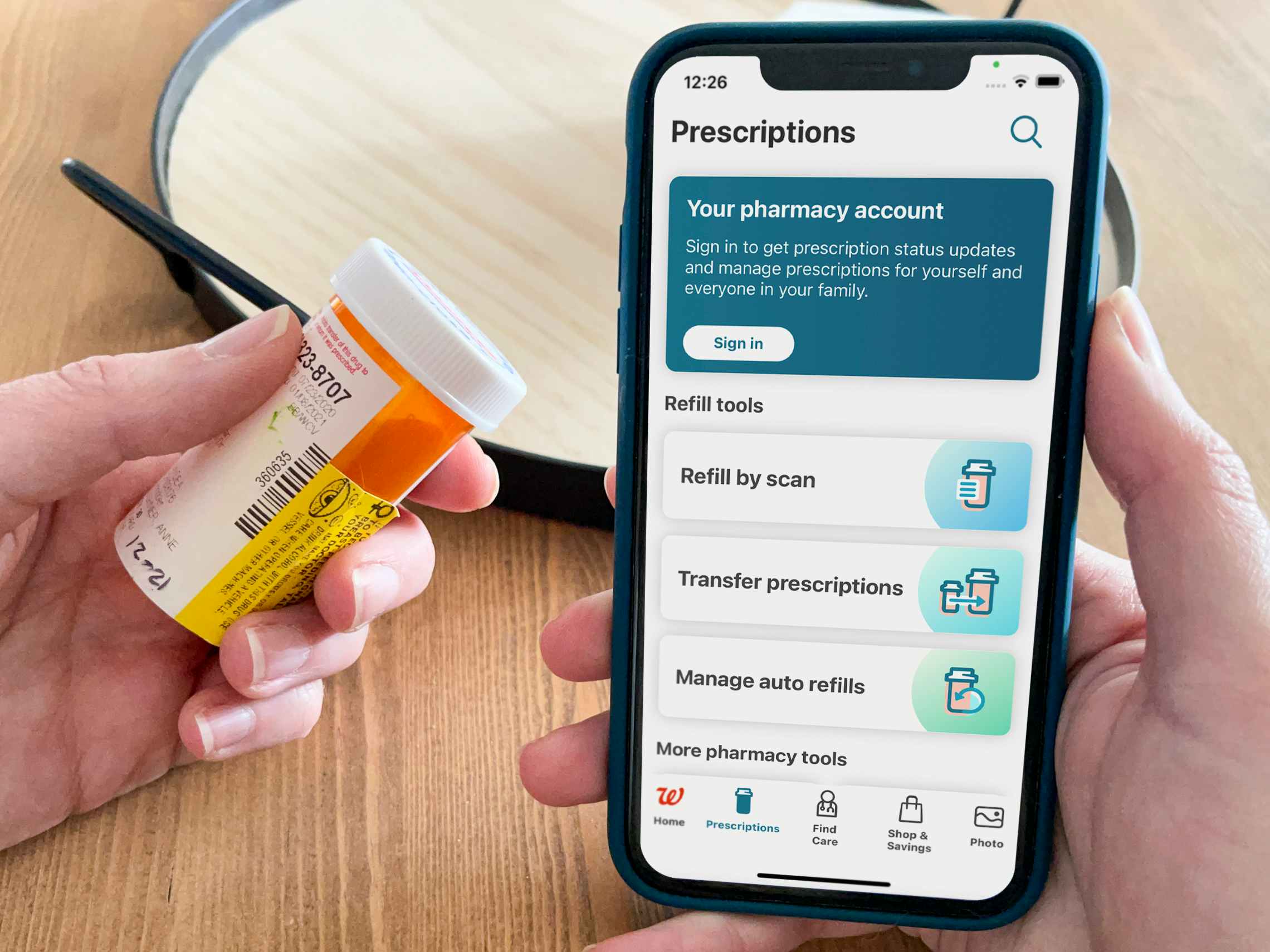 A prescription bottle held next to the Walgreens app.