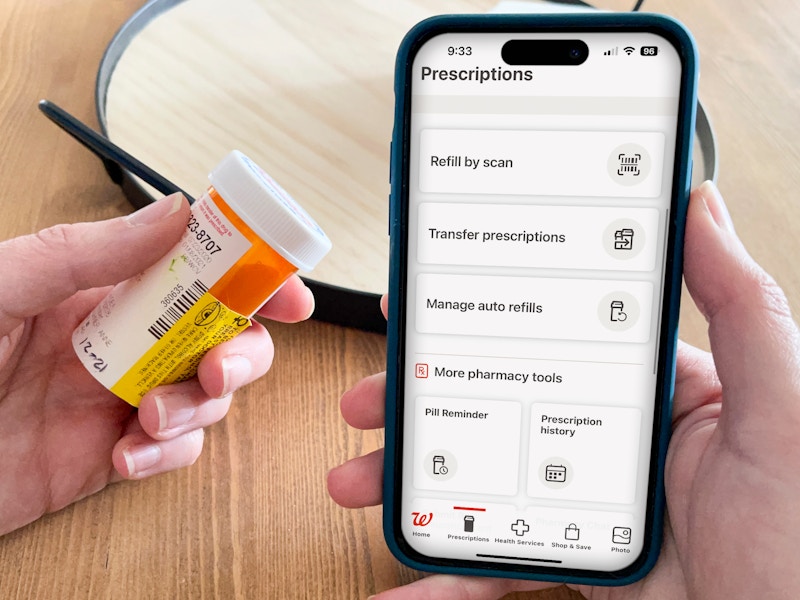 A prescription bottle held next to the Walgreens app.