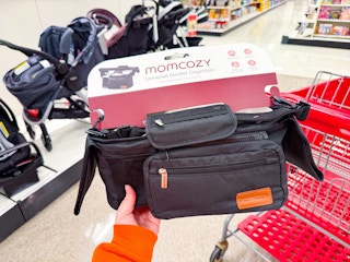 hand holding a momcozy stroller organizer in front of a target cart