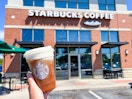 someone holding a coffee with cold foam outside of starbucks