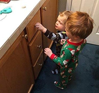 two kids pulling a cabinet open