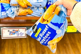 hand picking up a bag of signature select russet potatoes