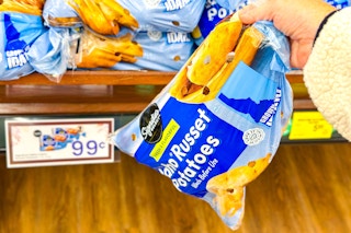 hand picking up a bag of signature select russet potatoes