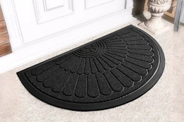 Lifestyle image of a black half round doormat in front of door outside