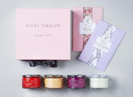 three colorful jars of candles next to a pink box