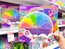 hand holding a rainbow loom set in front of a target shelf