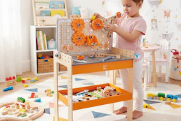 child playing with the Hape tool bench