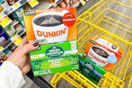 hand holding dunkin' and green mountain coffee