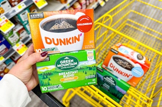 hand holding dunkin' and green mountain coffee