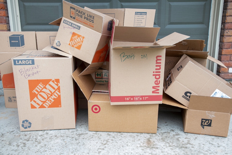 Pile of moving boxes in front of a house.