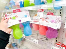 hand holding a 2-pack of munchkin sippy cups at target