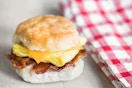 A Chick-fil-A breakfast sandwich on a table next to a napkin.