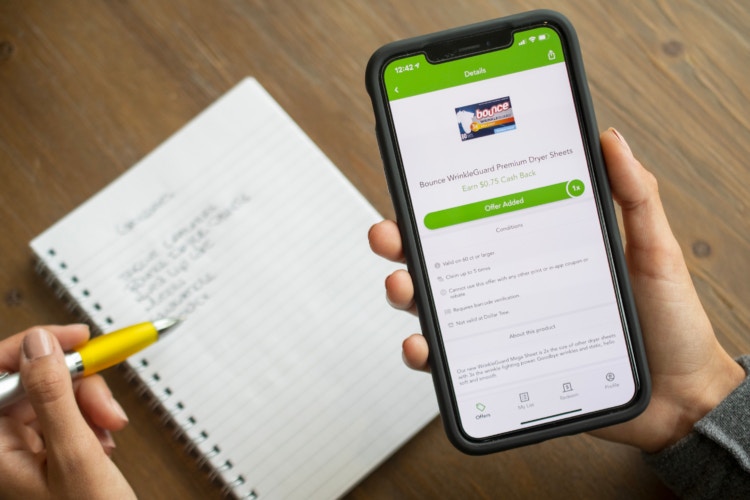 The checkout 51 app, with a deal for dryer sheets open and a grocery list on the table behind it.