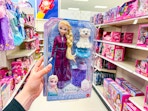 hand holding a disney frozen else fashion doll set in a target aisle