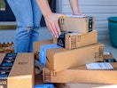 person picking up amazon boxes