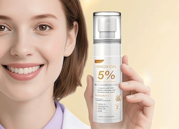 a person holding a bottle of hair serum