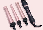 a pink curling iron with attachments