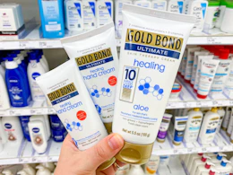 hand holding 3 gold bond healing hand creams in front of target shelf