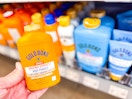 hand holding a yellow container of Gold Bond powder