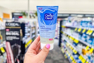 person holding clean and clear exfoliating cleanser in an aisle