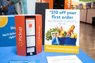 Counter at Walmart that has a sign for pickup and a sign that says $10 off your first order