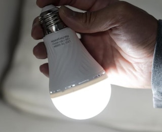 a hand holding a light bulb