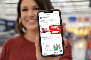 person holding iphone in walmart with ibotta app screenshot