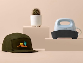 a Cricut hat press on display with a hat with a patch on it