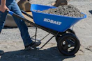 person pushing a blue Kobalt wheelbarrow