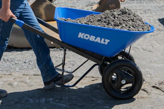 person pushing a blue Kobalt wheelbarrow