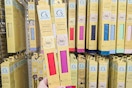 person holding 2 packs of vinyl craft paper in front of a display