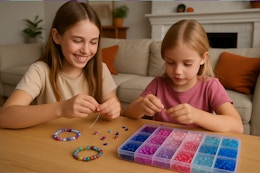 two girls making bracelets with glass beads 