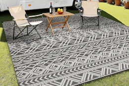 an outdoor rug by a rv