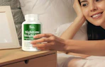a person holding a bottle of supplements next to their bed