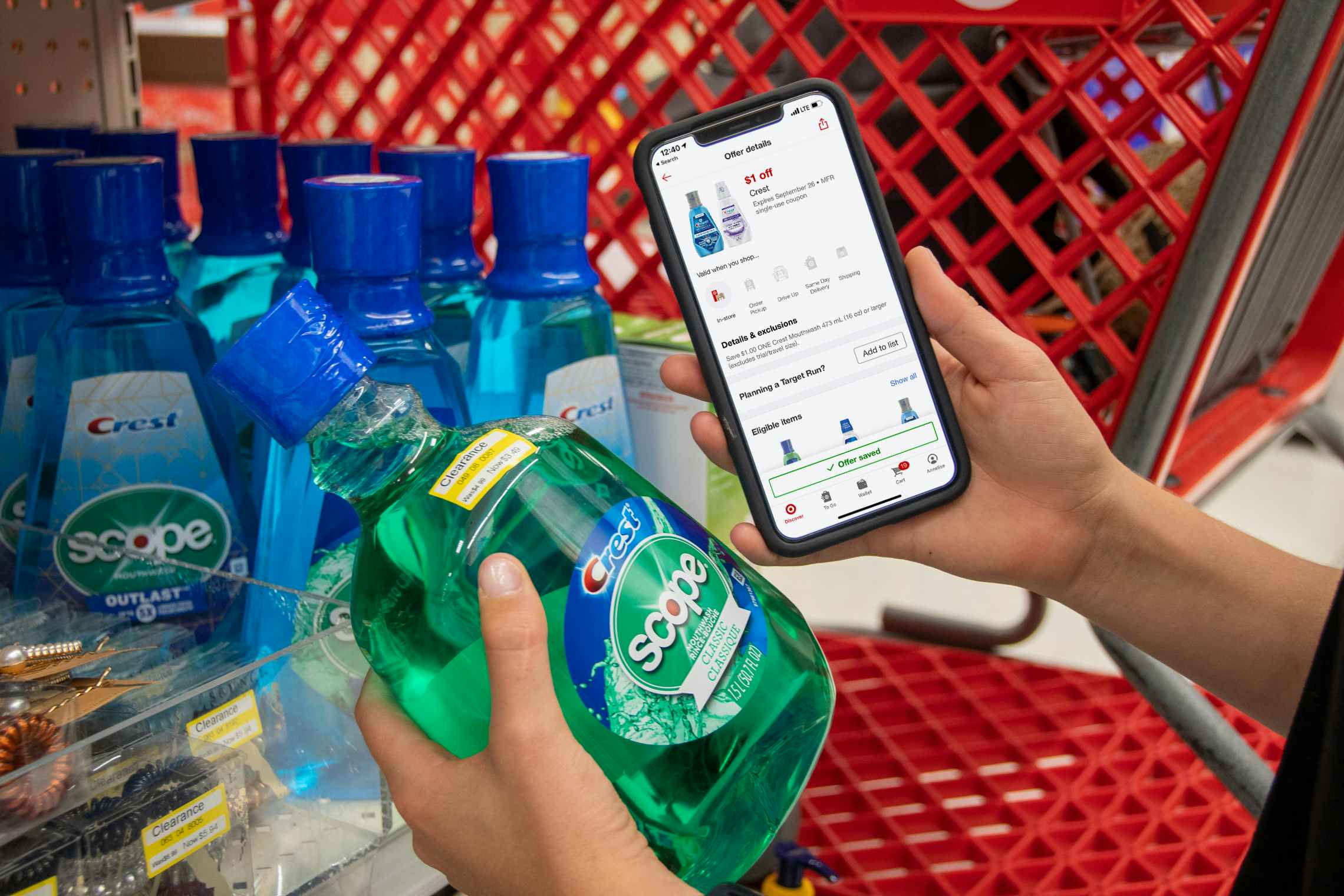 A person holding their phone displaying a Target circle app coupon next to a bottle of Scope mouthwash with a clearance sticker in Target...