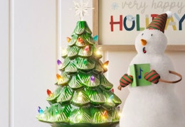green lit battery operated ceramic tree next to a snowman