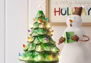 green lit battery operated ceramic tree next to a snowman