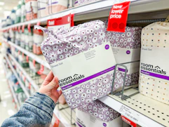 hand holding Room-Essentials-sheet-sets on target shelf