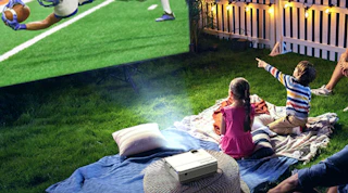 a family watching a football game on a projector outside