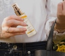 a person pulling a facial spray out of their purse