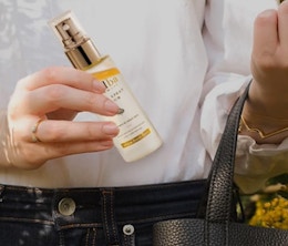 a person pulling a facial spray out of their purse