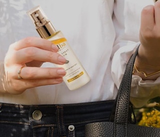 a person pulling a facial spray out of their purse