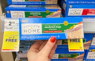 hand holding a box of complete home food storage sandwich bags next to a sale tag at walgreens