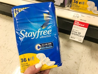 hand holding stayfree pads in front of promotion sign at target
