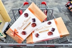 2 boxes of russell stover chocolates in a cart